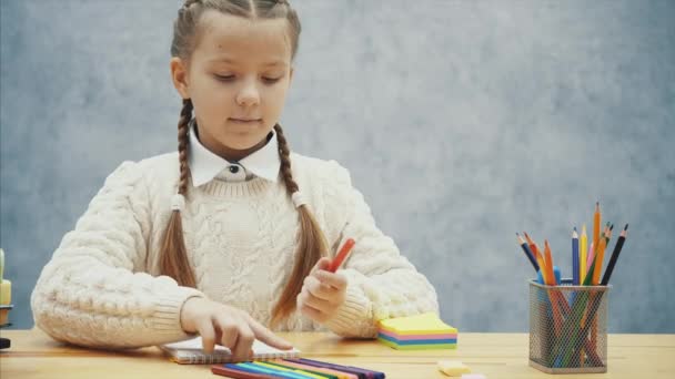 Mooie artiest kiest rode en zwarte markeerstiften om ongebruikelijke foto te tekenen. — Stockvideo