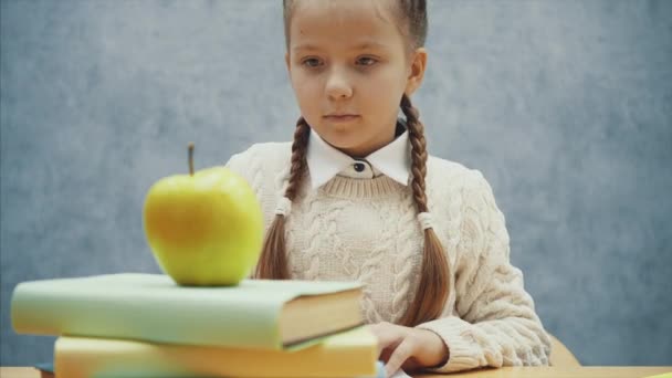 Liten hungrig elev stoppar en inlärningsprocess för att lukta ett äpple. — Stockvideo