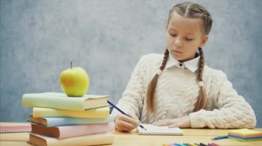 Schoolgirl yazma durur ve lezzetli sarı elma kokuyor.