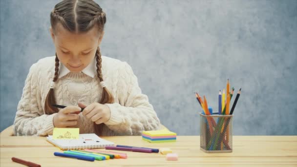 Νίκαια μαθήτρια έχει μια καλή στιγμή χρωματισμό μια εικόνα. — Αρχείο Βίντεο