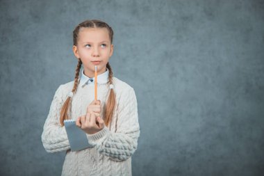 Akıllı bir görünüm ile zeki bir öğrenci, kalem ile el yükseltir gri arka planda izole edilir