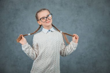 Bilge bir genç neşeli kız eğleniyor ve gri arka plan üzerinde izole.