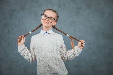 Bilge bir genç neşeli kız eğleniyor ve gri arka plan üzerinde izole.