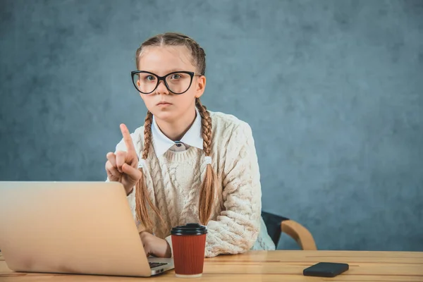 Kid points finger up isolated . Schoolgirl with laptop pointing upwards. Schoolgirl has an idea or recommend check this out. This direction. — Stock Photo, Image