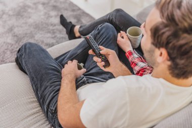 Genç mutlu çift kapalı bir kanepede oturan ve Tv izlerken Fotoğraf..