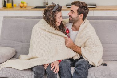 Genç çift kendi dairesinde rahatlatıcı, kanepede yatan, bir film izlerken.