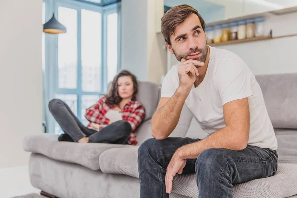 Pareja discuten. La esposa gritó a su marido desesperado, sentado en el sofá de la sala de estar en casa. Un hombre no mira a su esposa . —  Fotos de Stock