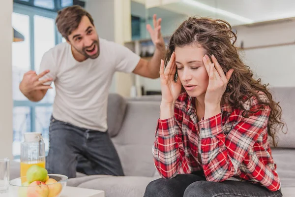 Casamento casal sentado na cama cinza e discutindo. Retrato de marido irritado grita chorando esposa decepcionada durante uma briga tendo conflito em casa. Problemas de relacionamento familiar . — Fotografia de Stock