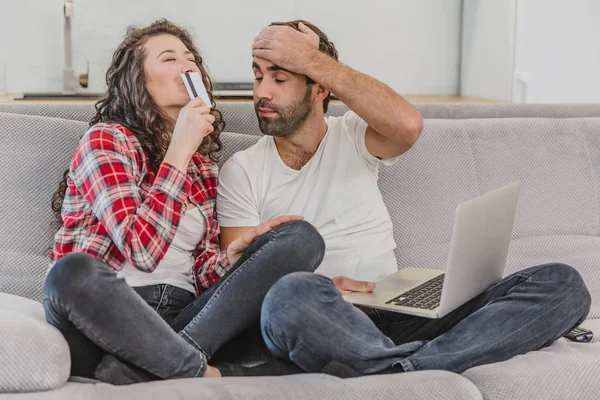 Dobrý pár při nakupování online pomocí notebooku a s úsměvem při sezení doma na gauči. — Stock fotografie