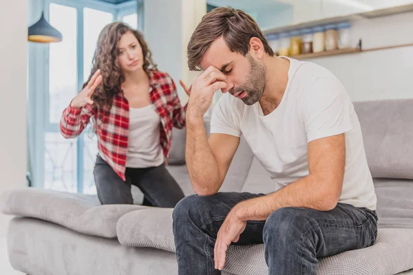 Stel argumenteren. De vrouw schreeuteerde naar haar wanhopige man, zittend op de Bank in de woonkamer thuis. Een man kijkt niet naar zijn vrouw. — Stockfoto