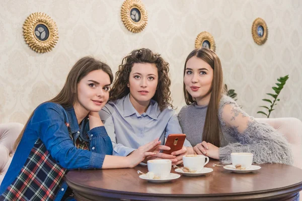 De drie beste vrienden kwamen om koffie en roddels te drinken. Meisjes zijn leuk en lachen. Meisjes met mooi zwart haar. — Stockfoto