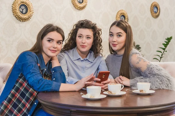 En iyi üç arkadaş kahve içmeye ve dedikodu yapmaya geldi. Kızlar eğlenceli ve güler. Güzel siyah saçlı kızlar.