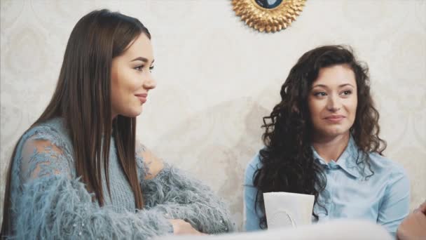 Three friends decided to meet. During this time they sit in a cafe and chat smiling. Glad to see each other. — Stock Video