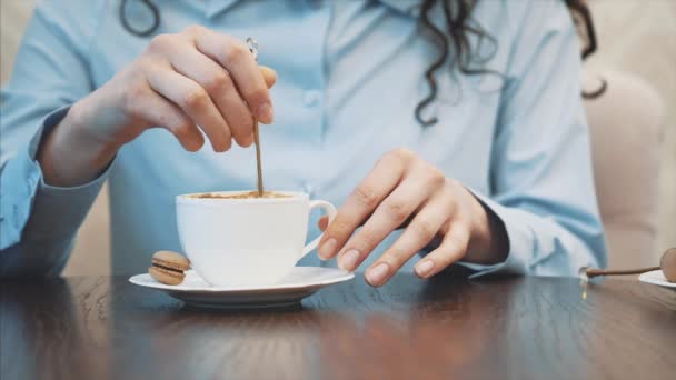 Mladá hezká dívka, co sedí v kavárně. Během této doby je to lžička cappuccino. Příjemný vkus na kávu a klid. — Stock video