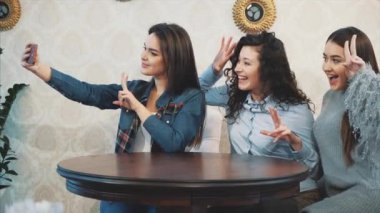 Genç üç iyi genç kız bir kafede oturuyor ve iletişim zaman harcamak