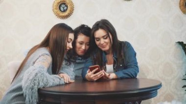 Genç üç iyi genç kız bir kafede oturuyor ve iletişim zaman harcamak