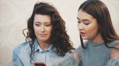 Mutlu çeşitli arkadaşlar öğle yemeği sırasında kafede birlikte telefon kullanarak. Akıllı telefon ekranına bakıyorum. Gülen adam sosyal ağda komik video gösteriyor. Toplantıda iş arkadaşlarına online şaka. Eğlenceli.