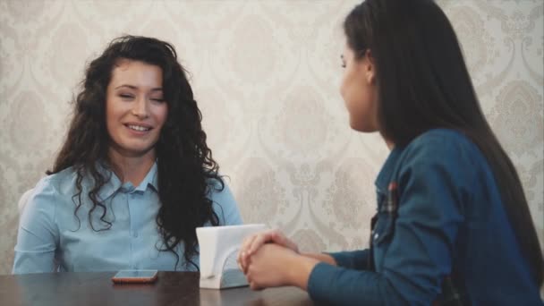 Heureuses trois belles filles assises dans un café avec leurs copines. Pendant ce temps, raconter et raconter diverses histoires. Profiter du temps ensemble tout en se relaxant dans le café . — Video