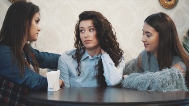 Tres lindas chicas lindas sentadas en un café. Durante esto, charlan y ven directamente en el ojo. Tener el pelo largo negro agradable . — Vídeos de Stock