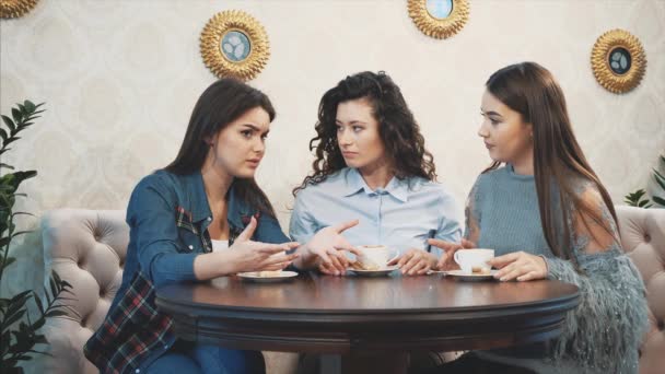 Tres buenas novias se conocieron en un café. Durante esta bebida simultáneamente capuchino. Tener el pelo largo y negro . — Vídeos de Stock