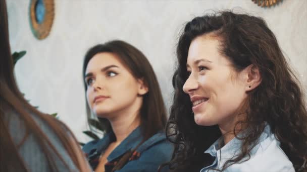 Kommunikation von drei jungen Mädchen in einem Café. an ernsten Themen sitzen. einen Sinn für Humor und lange schwarze Haare haben. — Stockvideo