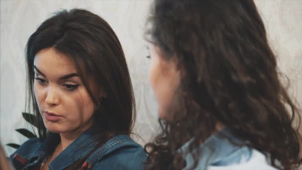 Communication de trois jeunes filles dans un café. Asseyez-vous sur des sujets sérieux. Avoir un sens de l'humour et de longs cheveux noirs . — Video