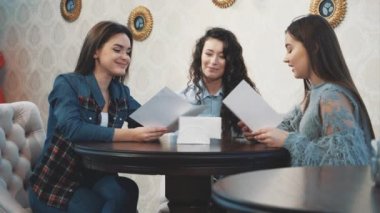Mutlu üç güzel kız kız arkadaşları ile bir kafede oturan. Bu esnada, çeşitli hikayeler anlatın ve anlatın. Kafede dinlenirken birlikte vakit geçirmenin keyfini çıkarın.