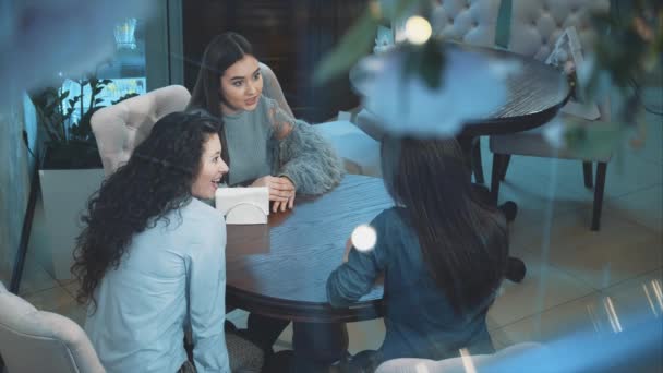 Trois jeunes belles filles sont assises dans un café. Pendant cette petite amie communiquer. Avoir de beaux cheveux longs noirs. Après une longue séparation . — Video