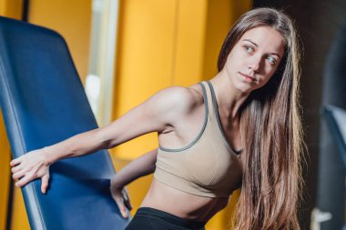 Güzel spor kız bir simülatör spor salonunda devreye girer. Güzel sıkılır rakam güzel kızla. Spor salonunda fitness kız.