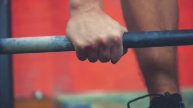 Spor salonunda spor giyen genç spor adamı. Bir eğitim oturumu sırasında ağır ağırlıkkaldırmak için gerginlik. Siyah bir t-shirt giymiş.
