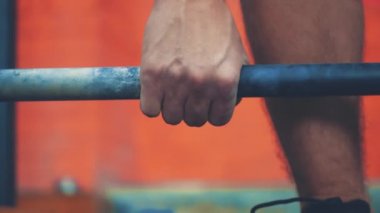 Binici omuzlarında çok ağır bir çubuk ile duruyor. O üst ve bir bar yerleştirir. Siyah tişört giymiş genç bir sporcu, spor salonunu tanıyın..