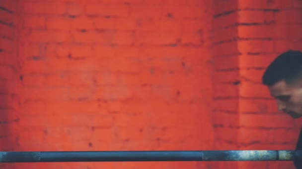 El jinete está de pie con una barra muy pesada en los hombros. Está en la cima y pone un bar. Un joven deportista vestido con una camiseta negra, conoce el gimnasio . — Vídeo de stock