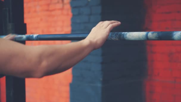 Il cavaliere è in piedi con una barra molto pesante sulle spalle. Lui è in cima e mette un bar. Un giovane sportivo vestito con una maglietta nera, conoscere la palestra . — Video Stock