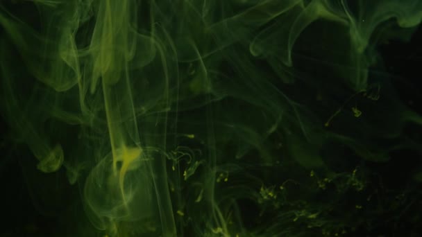 Természetes környezeti sárga fény füst lebeg kaotikusan a sötét-zöld háttér. — Stock videók