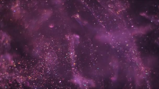 Streams full of tiny bokeh pink glittering bubbles are moving randomly and chaoticlally on the dark space background. — Stock Video