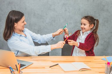 Anne ve kızı birlikte vakit geçirirler. Bu renkli kalemler sırasında bir oyun. Neşeli aile.