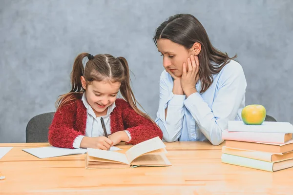 Mother who helps her daughter with the school homework