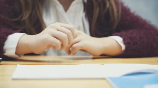 Primo piano di una mano da scolaretta sul tavolo. Fondo grigio . — Video Stock