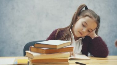 Çalışkan bir kız kitap okur. Annem yeşil bir elma getirdi. Gri bir arka plan üzerinde oturun.