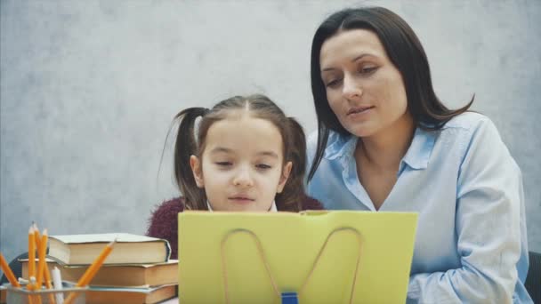 Матері, стає розчарування у зв'язку з дочкою в той час як робити домашнє завдання, сидячи за столом вдома у вивченні труднощі домашнє завдання. — стокове відео