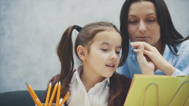 Madre frustrándose con su hija mientras hace la tarea sentada en la mesa en casa en dificultades de aprendizaje tarea . — Vídeos de Stock