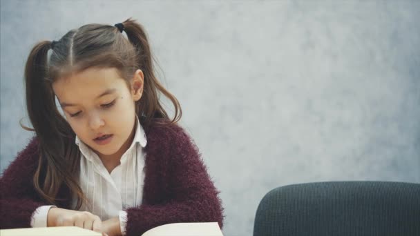 Moeder dochter het lezen van een boek tijdens het chatten. Grijze achtergrond. — Stockvideo
