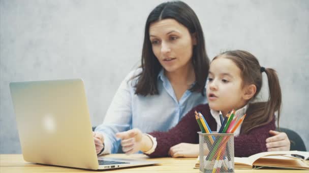 Mamma och dotter titta i den grå laptop. Under denna suddiga bakgrund. — Stockvideo