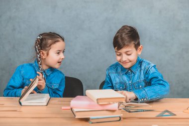 Akıllı erkek ve kız kitap yığını ile oturan, okuma, heyecan verici bir tartışma sahip.
