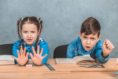 Masabaşında oturan öğrenciler, kitaplar açılıyor, çocuklar artık okumak istemediklerini gösteriyorlar..