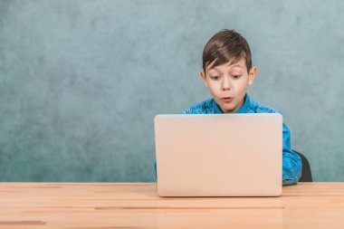 Sevimli küçük okul çocuğu masada oturan, onun laptop gördüğü bir şey şaşırttı.
