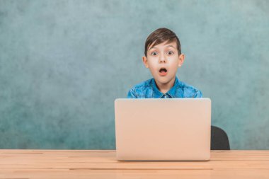 Sevimli küçük okul çocuğu masada oturan, onun laptop gördüğü bir şey şaşırttı.