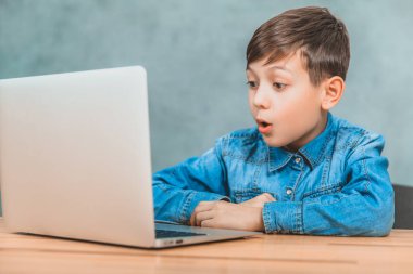 Sevimli küçük okul çocuğu masada oturan, onun laptop gördüğü bir şey şaşırttı.