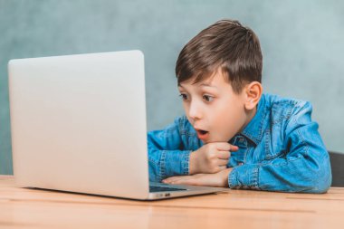 Sevimli küçük okul çocuğu masada oturan, onun laptop gördüğü bir şey şaşırttı.