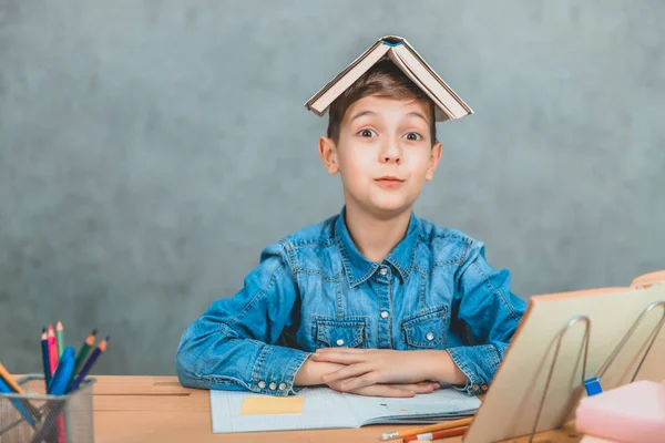 Divertido alumno jugando por ahí poniendo libro como un techo en su cabeza. Emociones, comportamiento tonto . — Foto de Stock